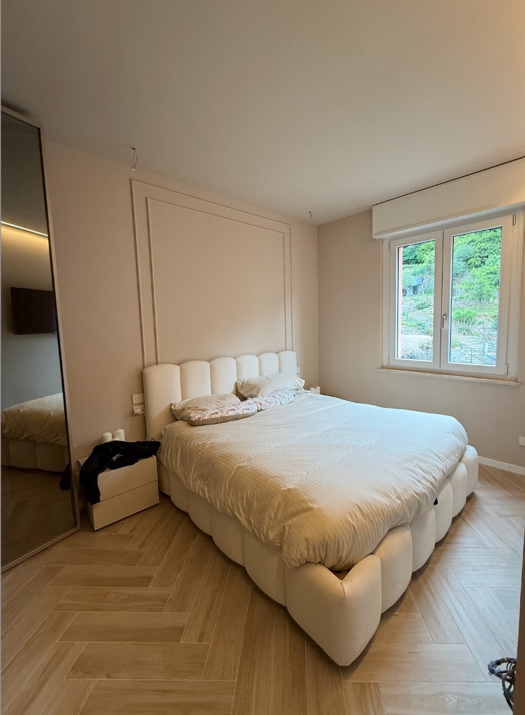Camera da letto con boiserie e parquet a spina di pesce